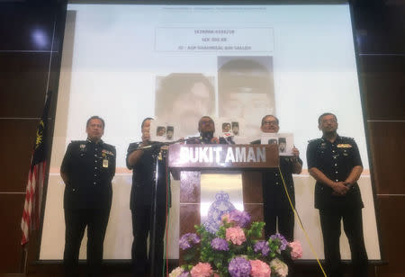 Malaysia's Inspector General of Police Mohamad Fuzi Harun (C) shows media mugshots of a suspect involved in the murder of Fadi Albatsh, during a news conference in Kuala Lumpur, Malaysia April 25, 2018. REUTERS/Joseph Sipalan