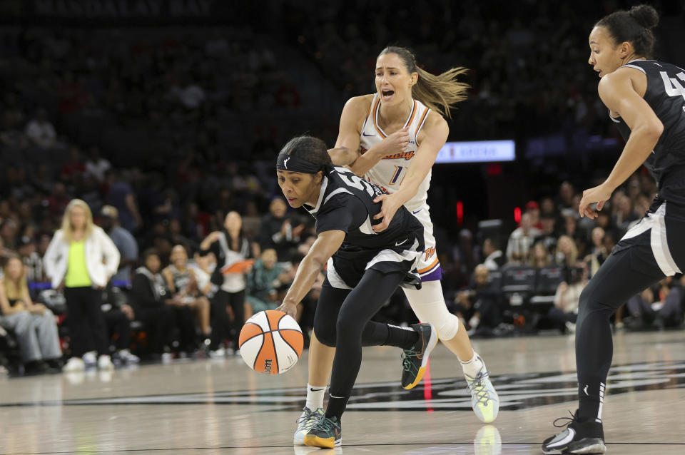 Las Vegas Aces guard Sydney Colson (51) steals the ball from Phoenix Mercury guard Rebecca Allen (11) as center Kiah Stokes, right, looks on during the first half of an WNBA basketball game Tuesday, May 21, 2024, in Las Vegas. (Steve Marcus/Las Vegas Sun via AP)