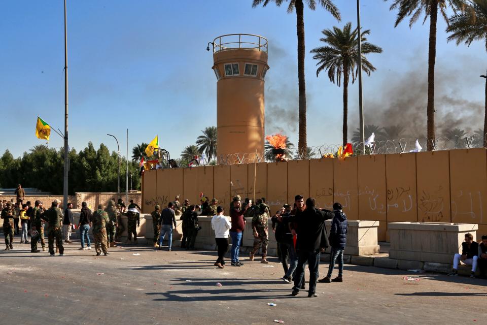 Protesters gather in front of the U.S. embassy compound, in Baghdad, Iraq, Tuesday, Dec. 31, 2019. Dozens of angry Iraqi Shiite militia supporters broke into the U.S. Embassy compound in Baghdad on Tuesday after smashing a main door and setting fire to a reception area, prompting tear gas and sounds of gunfire. (AP Photo/Khalid Mohammed)