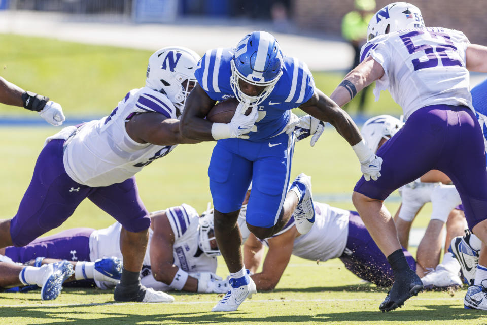 Duke's Jordan Waters, center, carries the ball between Northwestern's Najee Story, left, and Richie Hagarty (52) during the first half of an NCAA college football game in Durham, N.C., Saturday, Sept. 16, 2023. (AP Photo/Ben McKeown)