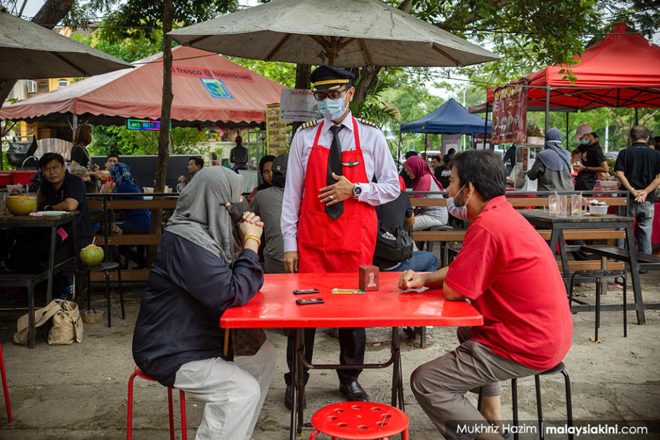 Former pilot Azrin Mohamad Zawawi, 44 and wife Latun Noralyani Meor Aminuddin, 41, run a small 'Kapten Corner' food stall selling local food together with other family members at Boomtown USJ, Selangor on Nov 4, 2020. Captain Azrin, a former Malindo airline pilot, lost his job after he was retrenched along with 2,200 other crew and staff.