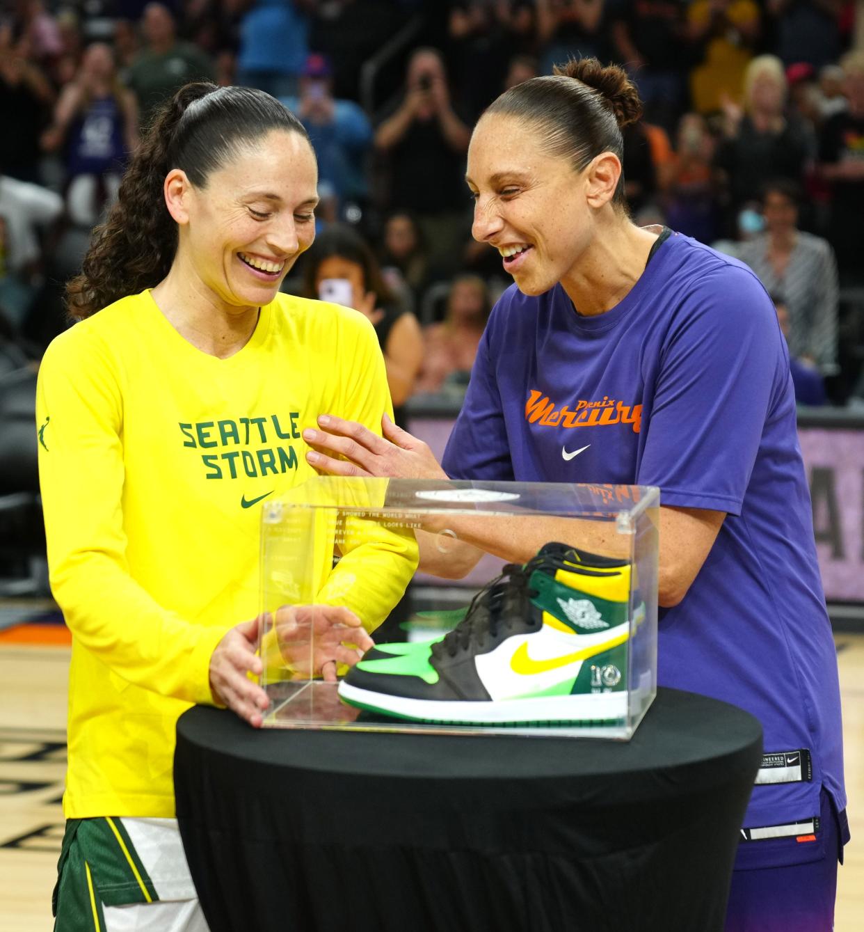 July 22, 2022;  Phoenix, Arizona; USA; Mercury’s Diana Taurasi (R) presents Storm’s Sue Bird a pair of costume Air Jordans prior to the first half at the Footprint Center.