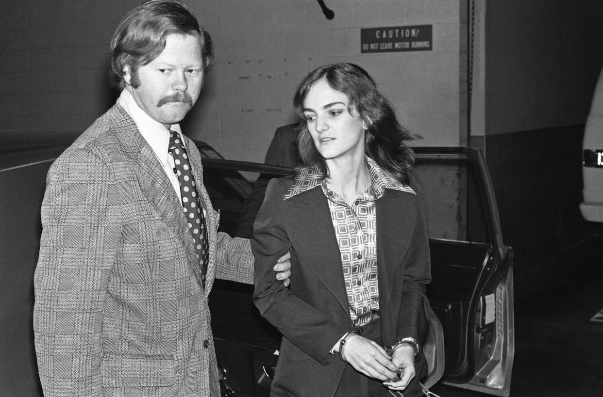 Patricia Hearst is escorted through the basement of the Federal Building in San Francisco