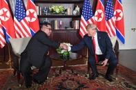 <p>President Donald Trump (R) shakes hands with North Korea’s leader Kim Jong Un (L) as they sit down for their historic US-North Korea summit, at the Capella Hotel on Sentosa island in Singapore on June 12, 2018. (Photo: Saul Loeb/AFP/Getty Images) </p>