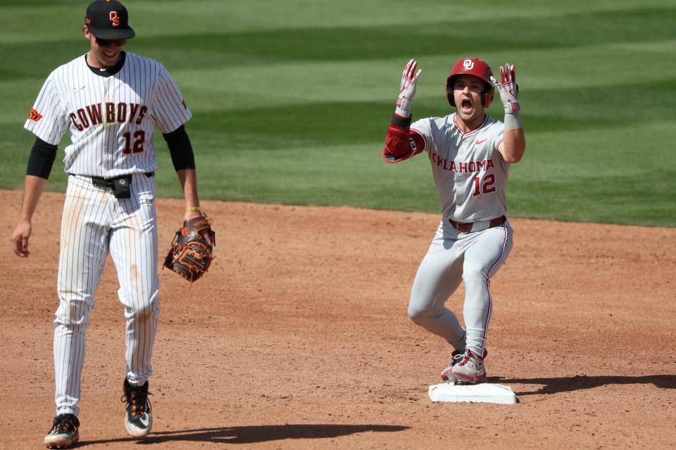 OU's Bryce Madron (12) celebrates beside OSU's Colin Brueggemann (12) after hitting a double in the third inning Saturday at O'Brate Stadium in Stillwater.
