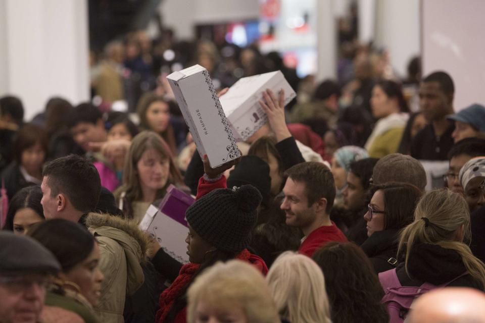 People carry shoes in Macy's during Black Friday sales in New York
