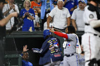 Toronto Blue Jays' Bo Bichette wears a sports coat and is greeted by Vladimir Guerrero Jr., right, after hitting a three run home run against Baltimore Orioles relief pitcher Bryan Baker which scored Alejandro Kirk and Matt Chapman during the sixth inning of a baseball game, Tuesday, Aug. 9, 2022, in Baltimore. (AP Photo/Terrance Williams)