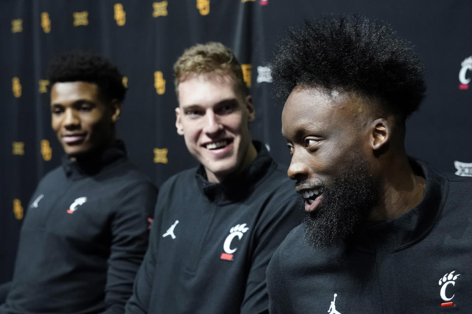 Cincinnati's John Newman III, right, speaks to the media while Ody Oguama, left and Viktor Lakhin, look on during the NCAA college Big 12 men's basketball media day Wednesday, Oct. 18, 2023, in Kansas City, Mo. (AP Photo/Charlie Riedel)