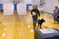 New Hampshire Republican U.S. Senate candidate Don Bolduc carries his ballot before casting his vote, with his dog "Victor", while voting, Tuesday, Sept. 13, 2022, in Stratham, N.H. (AP Photo/Charles Krupa)