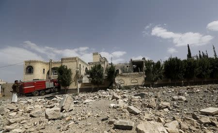 A man stands on the debris of the house of Ali al-Kuhlani, a former official in the regime of Yemen's former President Ali Abdullah Saleh, after it was hit by a Saudi-led air strike in Yemen's capital Sanaa July 2, 2015. REUTERS/Khaled Abdullah