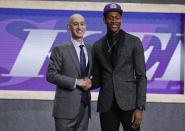 Virginia's De'Andre Hunter, right, is greeted by NBA Commissioner Adam Silver after being selected with the fourth pick overall by the Los Angeles Lakers during the NBA basketball draft Thursday, June 20, 2019, in New York. (AP Photo/Julio Cortez)