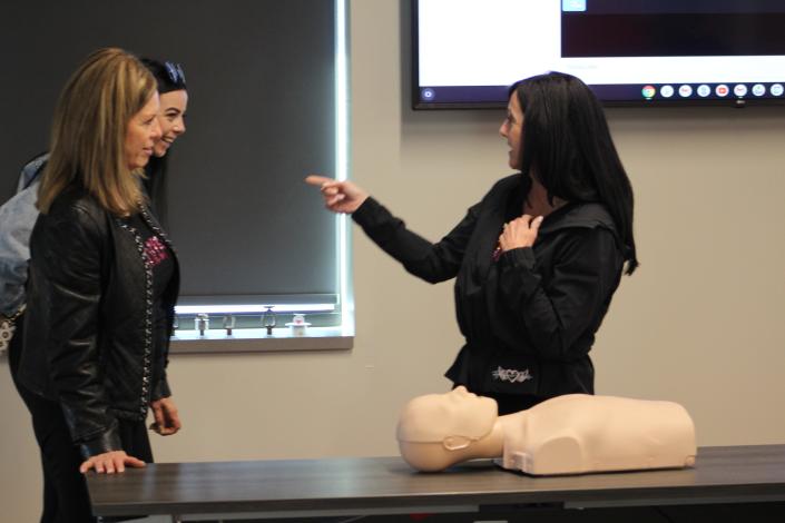 Vice President Kelley LaFontaine of the LaFontaine Automotive Group instructs members of her group to call 911 and find an AED for her patient during a CPR Training at the Brighton Fire Authority on Tuesday, April 5, 2022. Pictured left to right, Carol Peters, Savanna Hinsperger and LaFontaine.