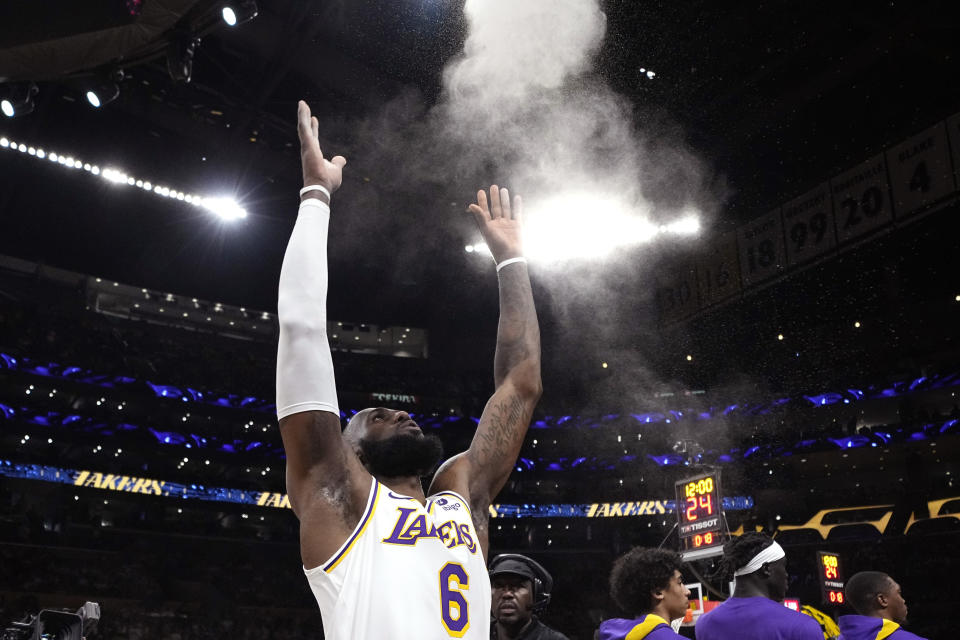 Los Angeles Lakers forward LeBron James tosses powder in the air prior to Game 3 of a first-round NBA basketball playoff series against the Memphis Grizzlies Saturday, April 22, 2023, in Los Angeles. (AP Photo/Mark J. Terrill)