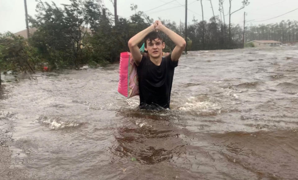 Matthew Aylen wades through waist deep water as he is rescued from his flooded home during Hurricane Dorian in Freeport, Bahamas.