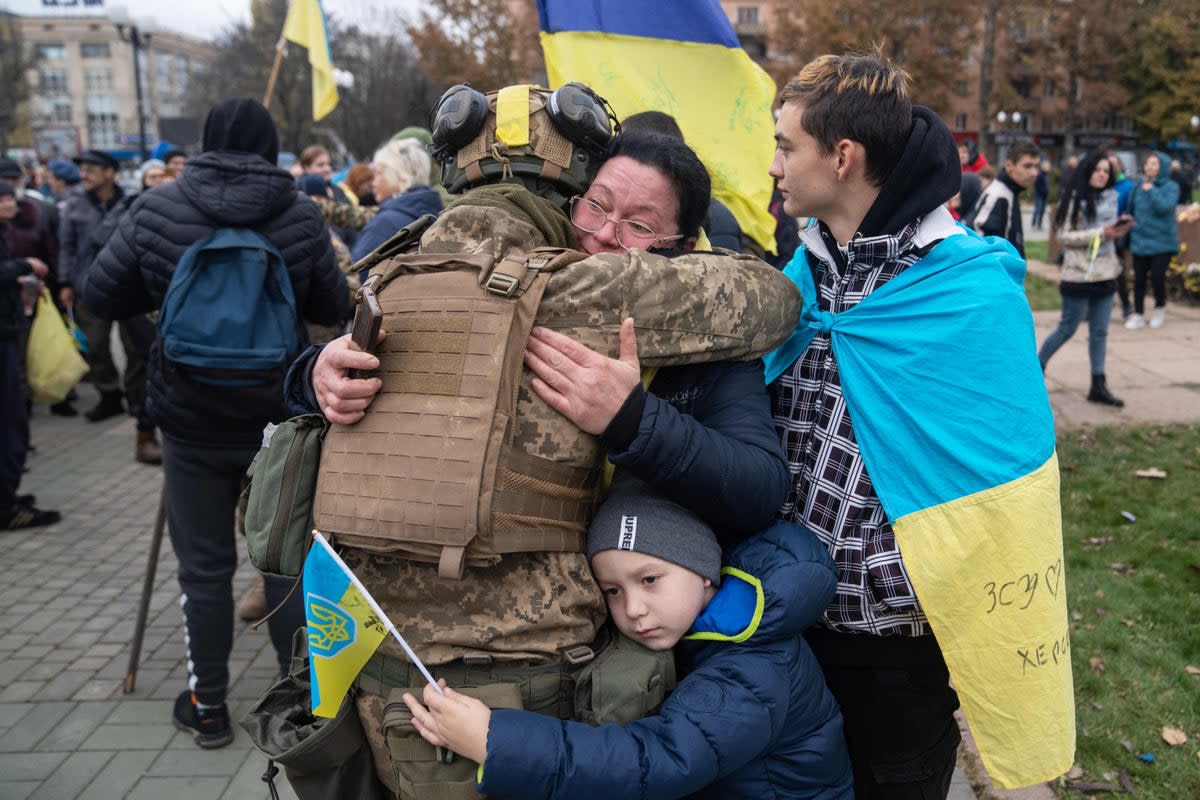 Local residents hug a Ukrainian soldier as they celebrate the liberation of the Kherson on 13 November (AFP/Getty)