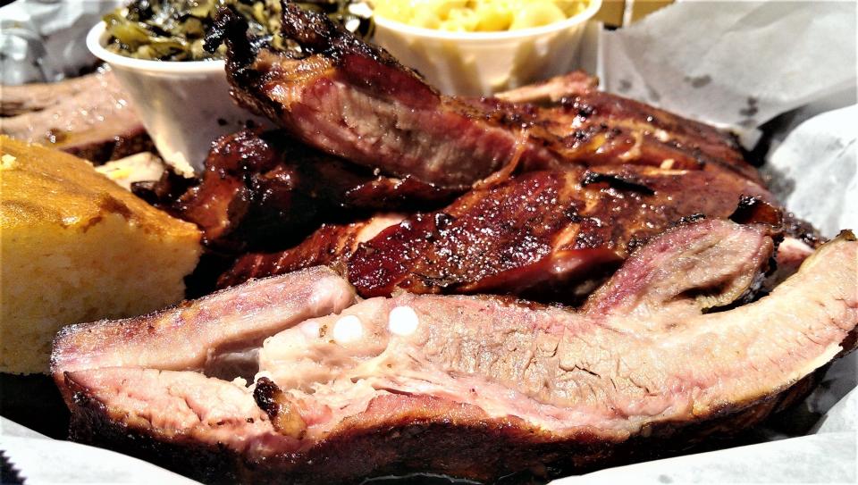 A half-rack of the long-bone, dry-rubbed and slow cooked ribs with mac-n-cheese and sweet collards greens with bacon, and cornbread at Stottlemyer’s Smokehouse.