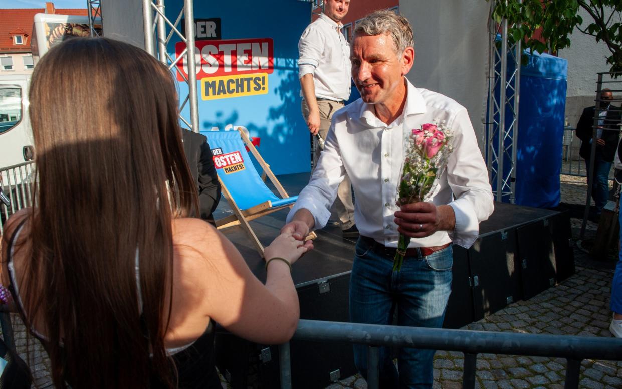 Mr Höcke accepts flowers from a supporter after his speech in Apolda