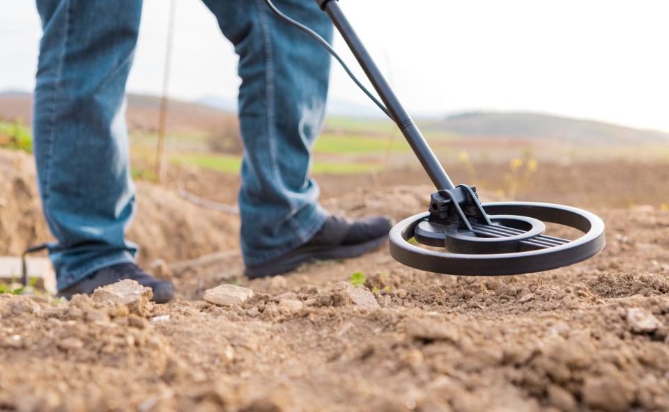 A person using a metal detector.