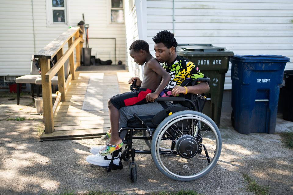 Damarion Allen, 15, gives his youngest brother Woody, a ride on his wheelchair, in the back of their Linden home in September. Damarion was paralyzed from the chest down on May 7, 2023, inside the Franklin County Juvenile Intervention Center.