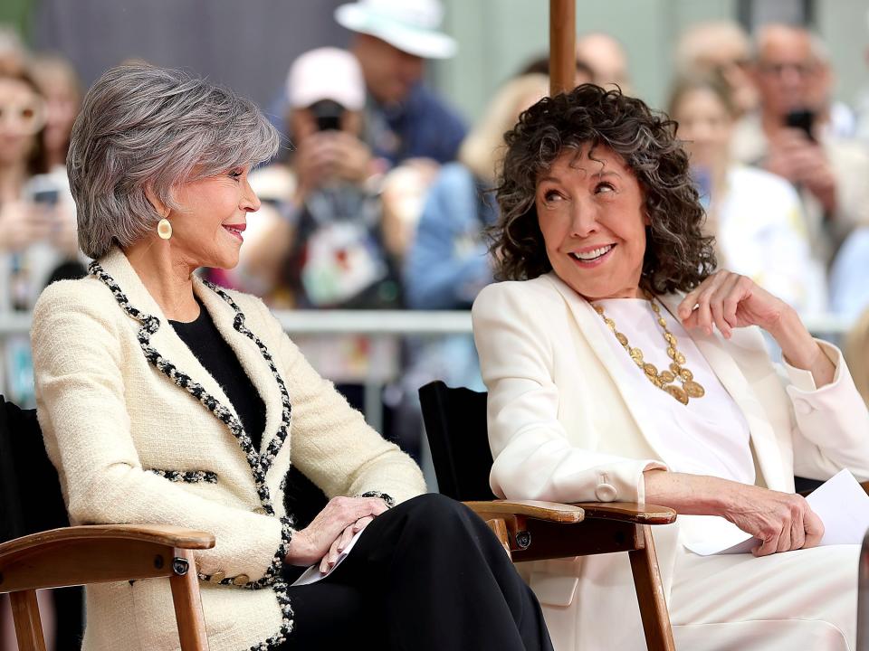 Jane and Lily sitting in chairs outside and smiling and laughing toward each other.