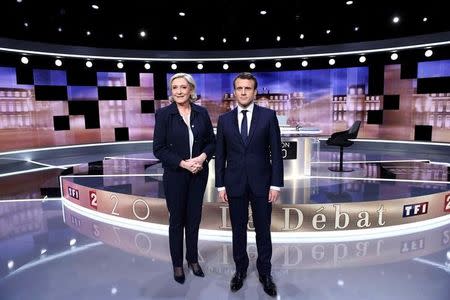 Candidates for the 2017 presidential election, Emmanuel Macron (R), head of the political movement En Marche !, or Onwards !, and Marine Le Pen, of the French National Front (FN) party, pose prior to the start of a live prime-time debate in the studios of French television station France 2, and French private station TF1 in La Plaine-Saint-Denis, near Paris, France, May 3, 2017. REUTERS/Eric Feferberg/Pool TPX IMAGES OF THE DAY