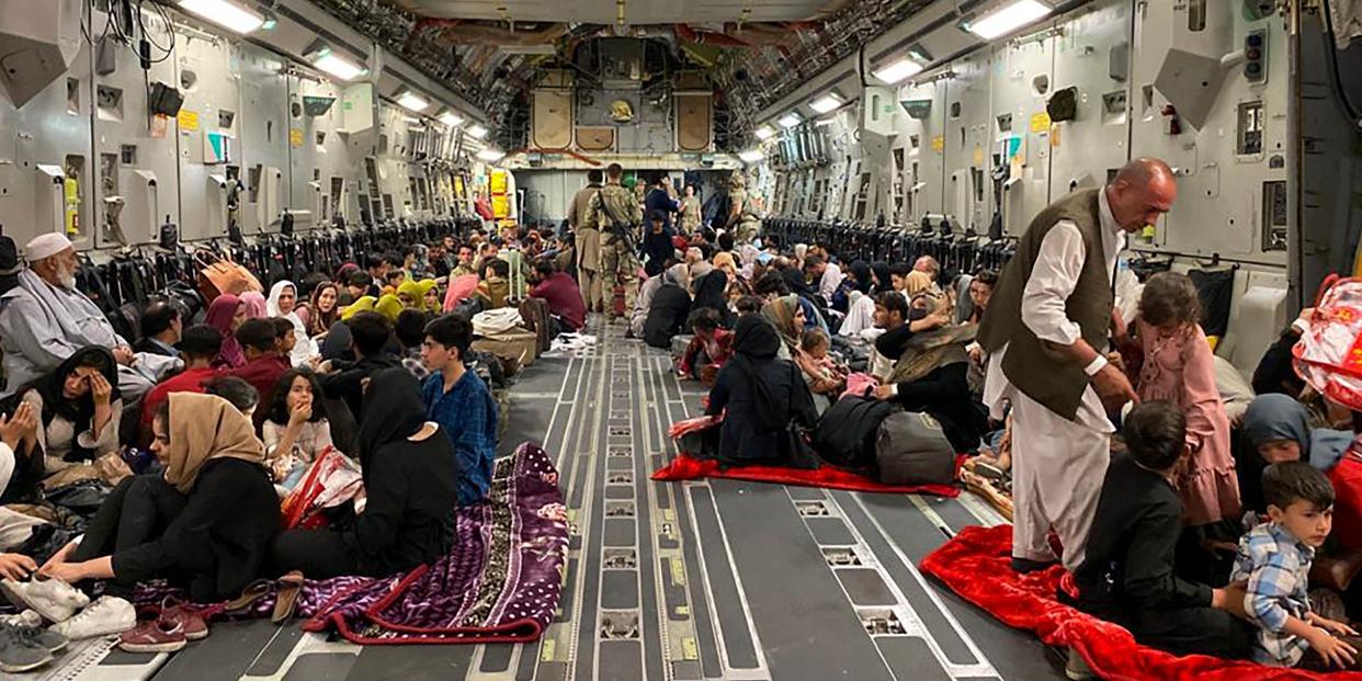 Afghan people sit inside a US military aircraft to leave Afghanistan, at the military airport in Kabul on August 19, 2021.