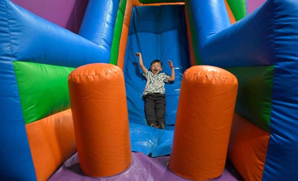 Oliver Prieto, de 6 años, de Kansas City, se lanza por un tobogán inflable durante la fiesta de cumpleaños de su hermana de 3 años, Evie Prieto.
