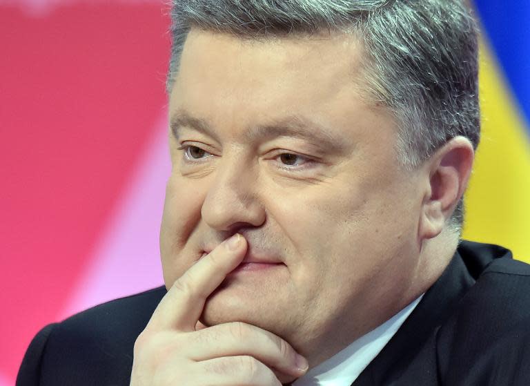 Ukrainian President Petro Poroshenko listens during a press-conference in Kiev on December 29, 2014