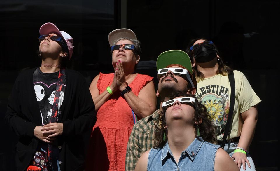 People watch the annular solar eclipse with safety glasses at a watch party at the Orlando Science Center on October 14, 2023 in Orlando, Florida.