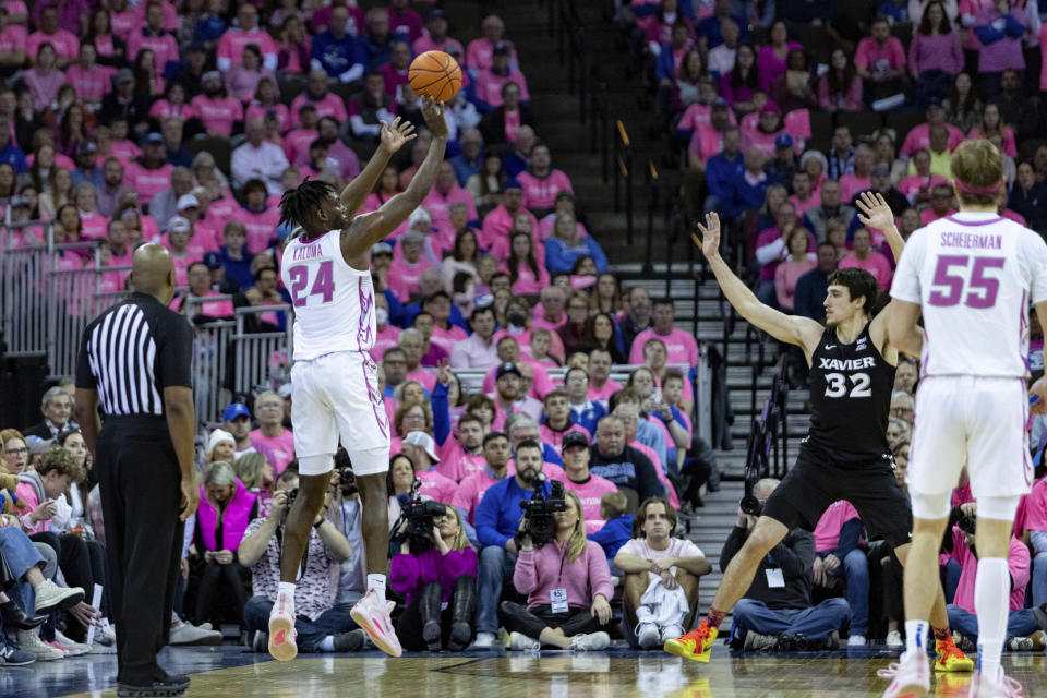 Creighton's Arthur Kaluma (24) makes a 3-point shot over Xavier's Zach Freemantle (32) in the second half during an NCAA college basketball game Saturday, Jan. 28, 2023, in Omaha, Neb. (AP Photo/John Peterson)