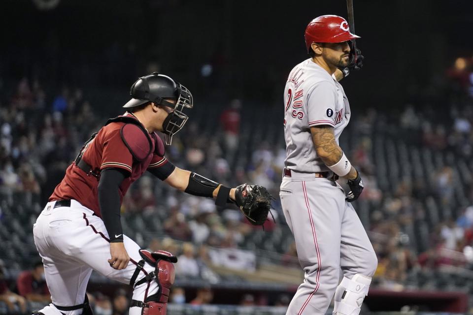 Arizona Diamondbacks catcher Carson Kelly, left, tags out Cincinnati Reds' Nick Castellanos, right, after a dropped third strike during the first inning of a baseball game Sunday, April 11, 2021, in Phoenix. (AP Photo/Ross D. Franklin)