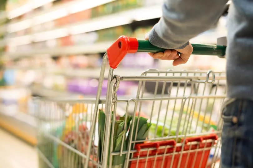 A closeup image of a shopper with a trolley in a supermarket