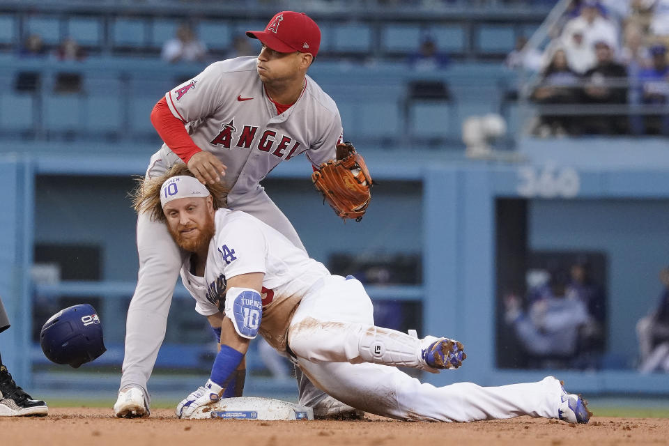 Los Angeles Dodgers' Justin Turner, bottom, slides safely into second base with a double under Los Angeles Angels shortstop Jose Iglesias during the first inning of a baseball game Friday, Aug. 6, 2021, in Los Angeles. (AP Photo/Marcio Jose Sanchez)