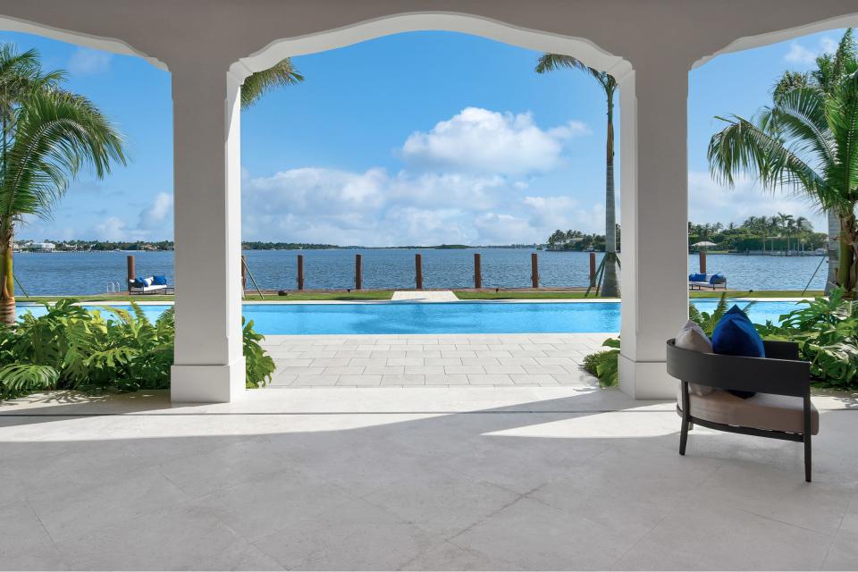 With gently shaped arches, the main loggia at 10 Tarpon Island looks across the south pool and the dock, straight down the Intracoastal Waterway.