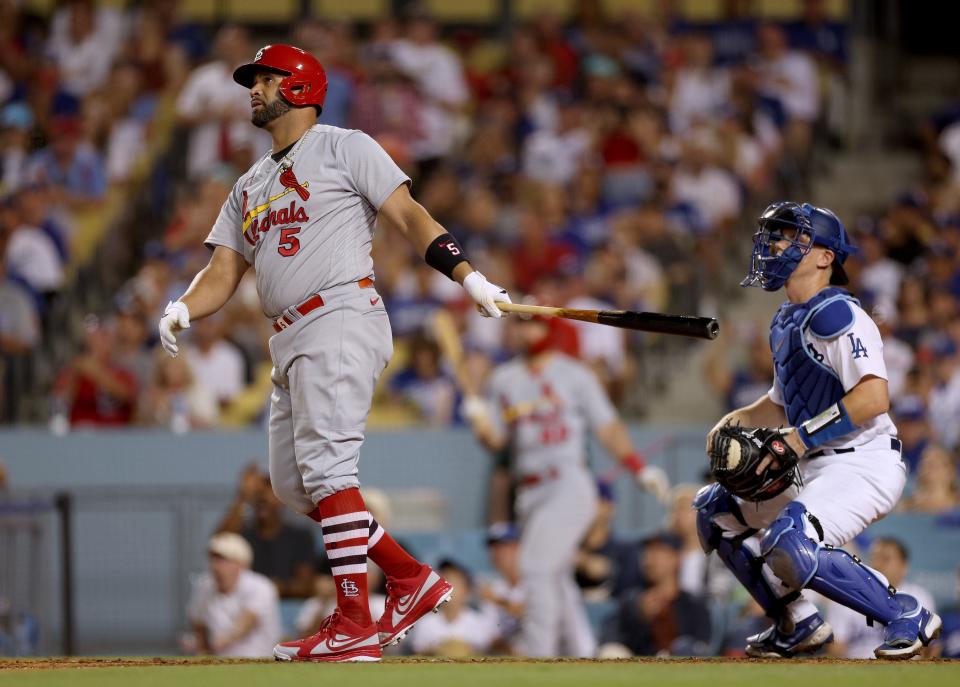 Albert Pujols watches the flight of home run No. 699.