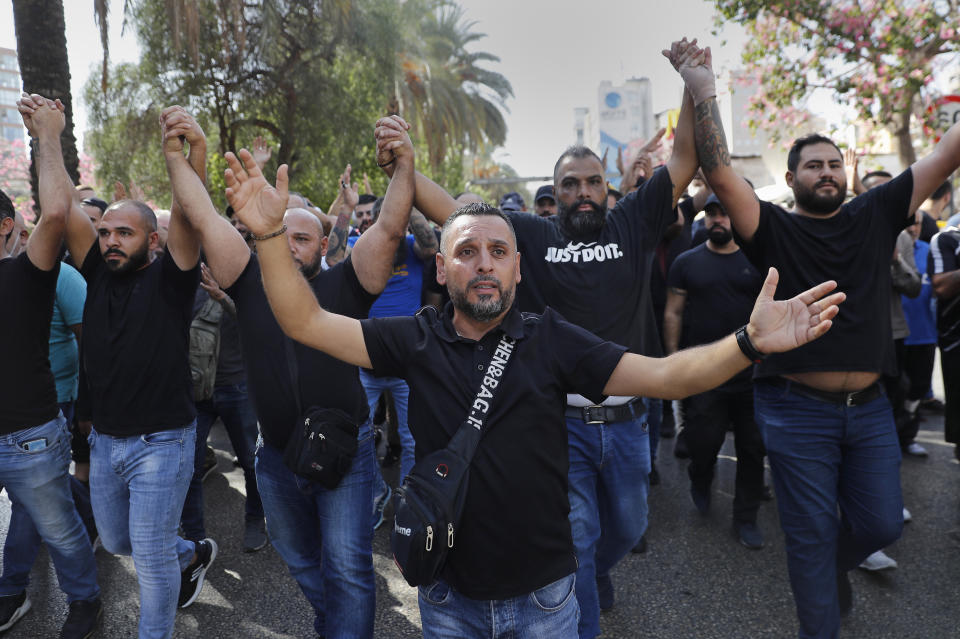 Supporters of the Shiite Hezbollah and Amal groups chant slogans against Judge Tarek Bitar, who is investigating last year's deadly seaport blast, during a protest in front of the Justice Palace, in Beirut, Lebanon, Thursday, Oct. 14, 2021. Lebanon's interior minister said at least five people have been killed in armed clashes in Beirut that erupted Thursday during protests against the lead investigator into last year's massive blast at the city's port. (AP Photo/Hussein Malla)