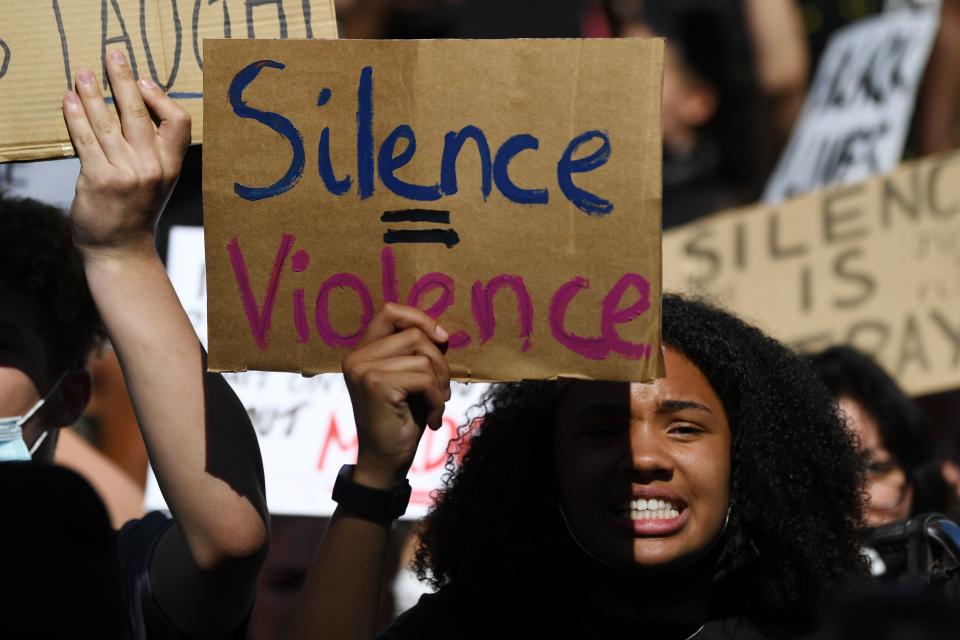 Demonstrators carry placards with slogans as they march near the US Embassy in London on May 31, 2020 to protest the death of George Floyd, an unarmed black man who died after a police officer knelt on his neck for nearly nine minutes during an arrest in Minneapolis, USA. - Hundreds gathered in central London and marched to teh US Embassy to protest the death of an unarmed black man in Minneapolis while in police custody that has sparked days of unrest in the US city and beyond. (Photo by DANIEL LEAL-OLIVAS / AFP) (Photo by DANIEL LEAL-OLIVAS/AFP via Getty Images)