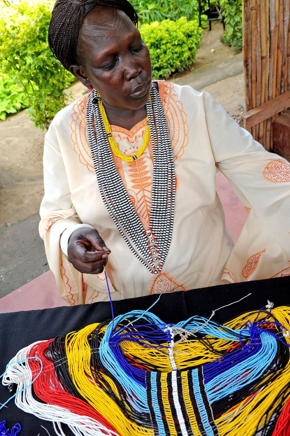 This undated image provided by the Santa Fe International Folk Art Market shows Mary Padar Kuojok working on a beaded garment as part of her work for The Roots Project: Juba, South Sudan. She will be among more than 150 artists and artisans from around the world taking part in the art market July 13-15 in Santa Fe, N.M. (AP Photo/The Roots Project/Santa Fe International Folk Art Market)