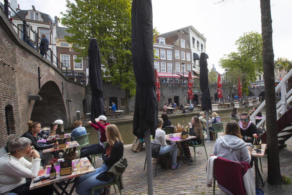 Dutch customers eager for their first drink of coffee or something stronger at a cafe terrace have flocked to outdoor seating as the Netherlands' lockdown eased in Utrecht, Wednesday, April 28, 2021. The Netherlands became the latest European country to begin cautiously relaxing its lockdown even as infection rates and intensive care occupancy remain stubbornly high. The Dutch follow Italy, Greece, France and other European nations in moving to reopen society and edge away from economically crippling lockdowns in the coming weeks. (AP Photo/Peter Dejong)