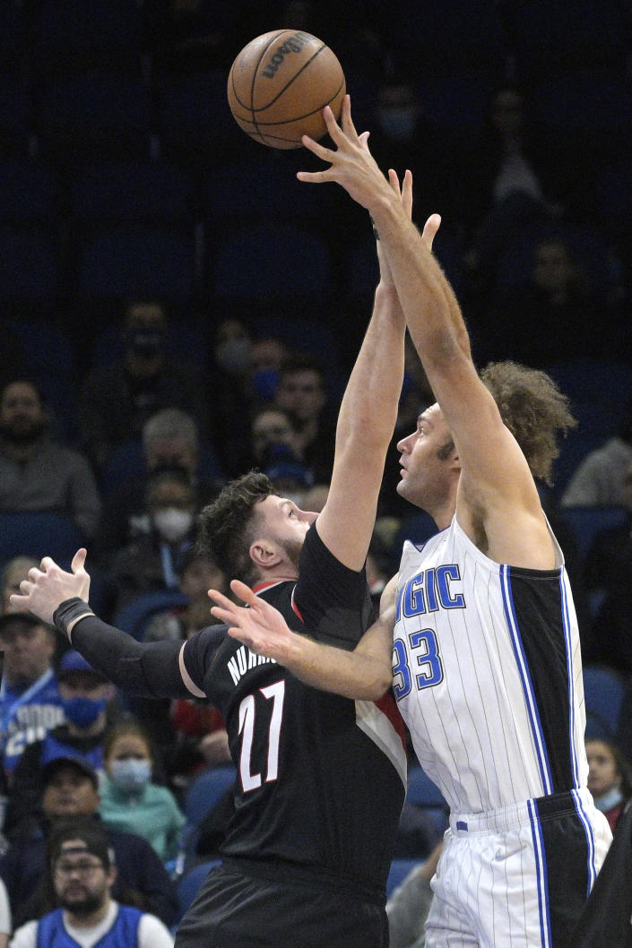 Orlando Magic center Robin Lopez (33) goes up to shoot in front of Portland Trail Blazers center Jusuf Nurkic (27) during the first half of an NBA basketball game, Monday, Jan. 17, 2022, in Orlando, Fla. (AP Photo/Phelan M. Ebenhack)