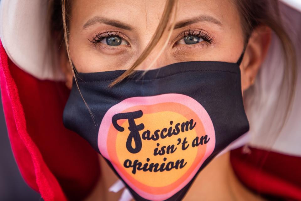 Jodie wearing a mask that says "Fascism isn't an opinion"