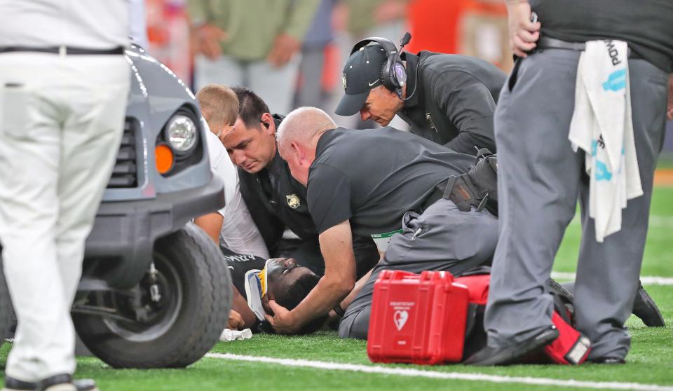 Army defensive lineman Dre Miller (97) is helped by medical trainers after suffering an injury against the Syracuse Orange during the second half at JMA Wireless Dome. Head coach Jeff Monken, right, looks on. Mandatory Credit: Danny Wild-USA TODAY Sports