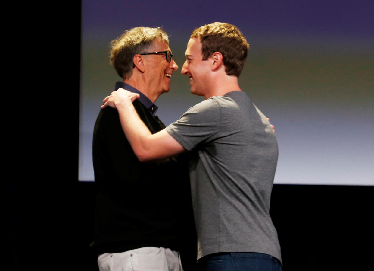 Philanthropist Bill Gates (L) embraces Facebook's Mark Zuckerberg during an announcement of the Chan Zuckerberg Initiative to 