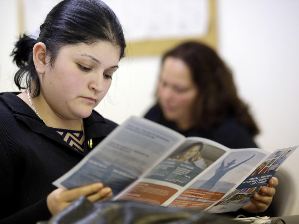 In this Tuesday, March 11, 2014 photo, Sara Rodriguez looks over an Affordable Care Act brochure, in Houston. Rodriguez, like others who gathered to listen to a presentation about President Barack Obama’s signature health care overhaul, says she can’t afford insurance, even for $50 a month. With two young children and barely $400 of disposable income a month, she struggles to feed her family. (AP Photo/David J. Phillip)