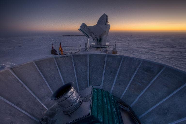 This undated handout photo courtesy of Steffen Richter shows the sun as it sets behind BICEP2 (in the foreground) and the South Pole Telescope (in the background)