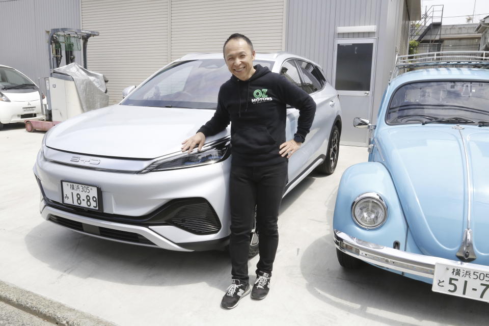Osamu Furukawa stands next to his new BYD ATTO 3 electric car, that’s parked besides a Volkswagen converted into an EV, in Yokohama, south of Tokyo, Tuesday, April 25, 2023. BYD Auto is part of a wave of Chinese electric car exporters that are starting to compete with Western and Japanese brands in their home markets. They bring fast-developing technology and low prices that Tesla Inc.'s chief financial officer says “are scary.” (AP Photo/Yuri Kageyama)