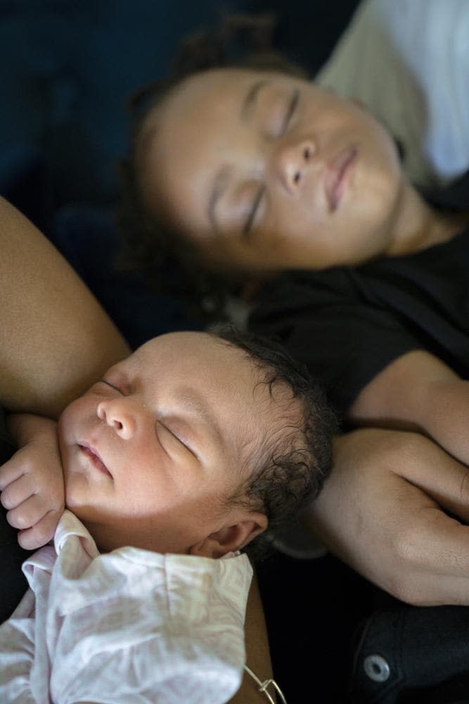 Aaliyah Wright, 25, of Washington, hold newborn daughter Kali, as her husband Kainan Wright, 24, of Washington, holds their sleeping son Khaza, 1, during a visit to the children’s grandmother in Accokeek, Md., Tuesday, Aug. 9, 2022. (AP Photo/Jacquelyn Martin)