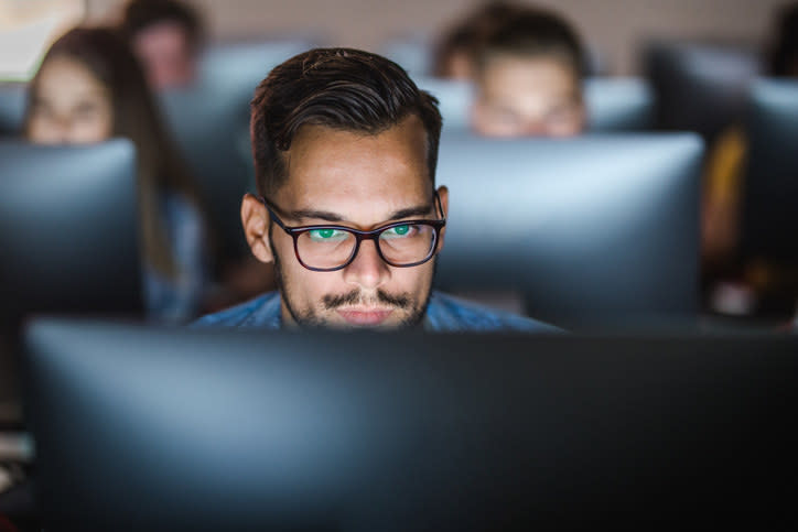 A student writing at computer in a computer lab