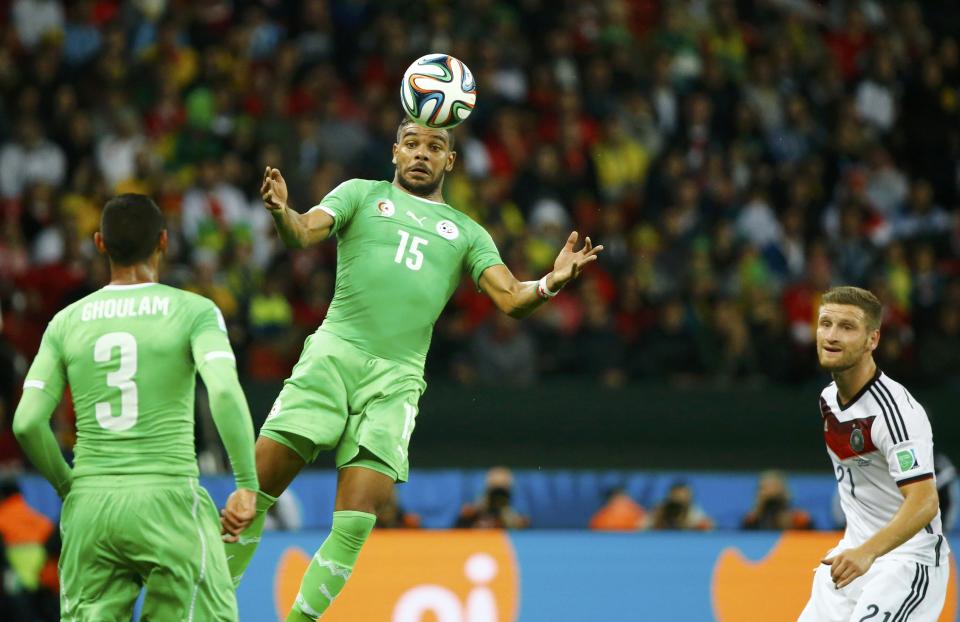 Algeria's El Arabi Soudani (C) controls the ball next to teammate Faouzi Ghoulam (L) and Germany's Shkodran Mustafi during their 2014 World Cup round of 16 game at the Beira Rio stadium in Porto Alegre June 30, 2014. REUTERS/Stefano Rellandini