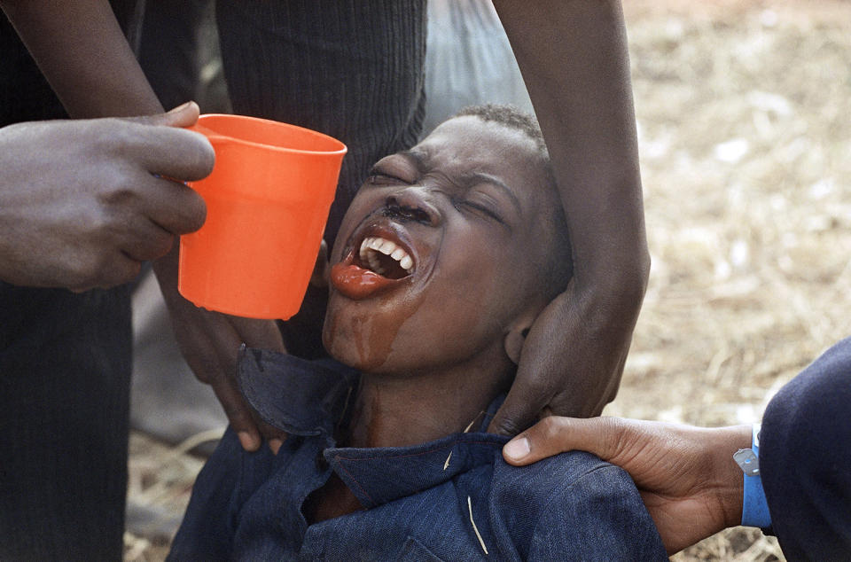 <p>A weak Rwandan Hutu refugee strains to receive water at the Kibumba refugee camp, Aug. 1, 1994, near Goma, Zaire (DRC). Relief organizations and military specialists were scrambling to provide clean drinking water for some 1.2 million refugees within Zaire. (Photo: Jacqueline Larma/AP) </p>